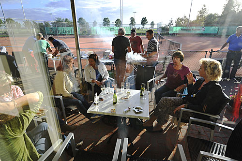 15091950 Barbecue zonsondergang rond de tafel door ruit